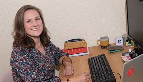 Hannah Swierstra sitting at her office desk