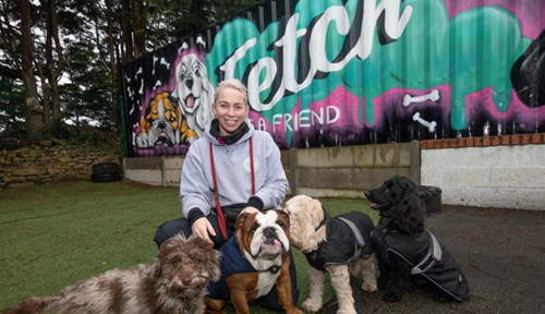Abbie Perkins, owner of Fetch a Friend, with a number of dogs at the day care.